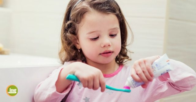Kleines Mädchen mit Zahnbürste und Zahnpasta. Information Mundgesundheit klärt zu Fluoriden auf.