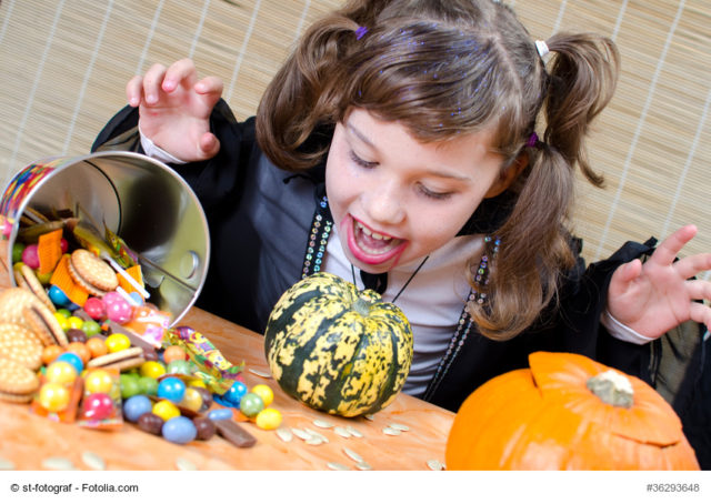 kleines vampirmädchen mit süßigkeiten zu halloween