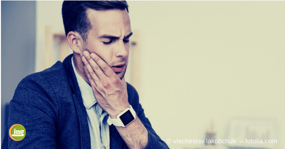 Ein Mann hält sich die Wange, weil seine empfindlichen Zähne schmerzen. Information Mundgesundheit erklärt die Zusammenhänge!
