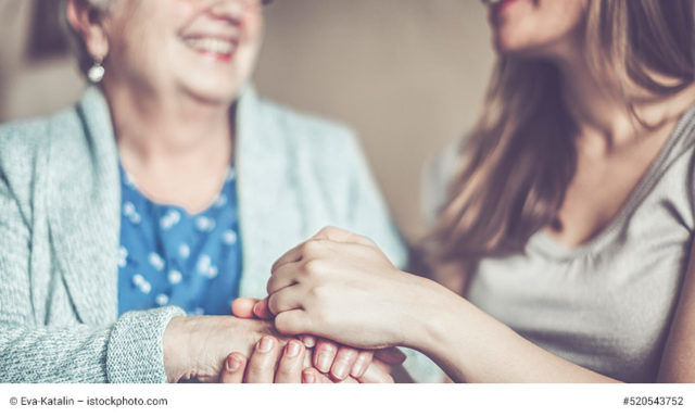 junge frau hält seniorin die hand zum internationalen Tag der Pflege