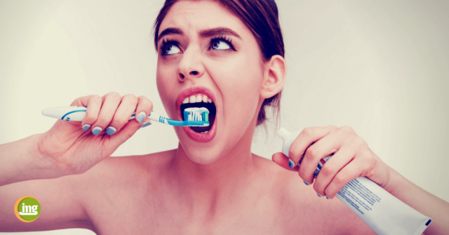 Junge Frau putzt sich die Zähne und ist erstaunt: 10 Fakten zur Zahnpasta von Information Mundgesundheit.