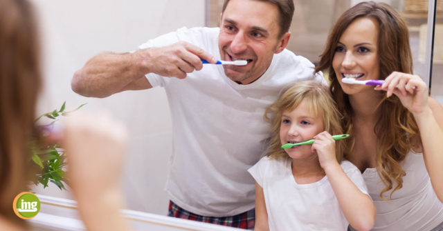 Vater und Sohn putzen sich im Badezimmer die Zähne. Information Mundgesundheit klärt auf: So helfen Eltern als gute Vorbilder..