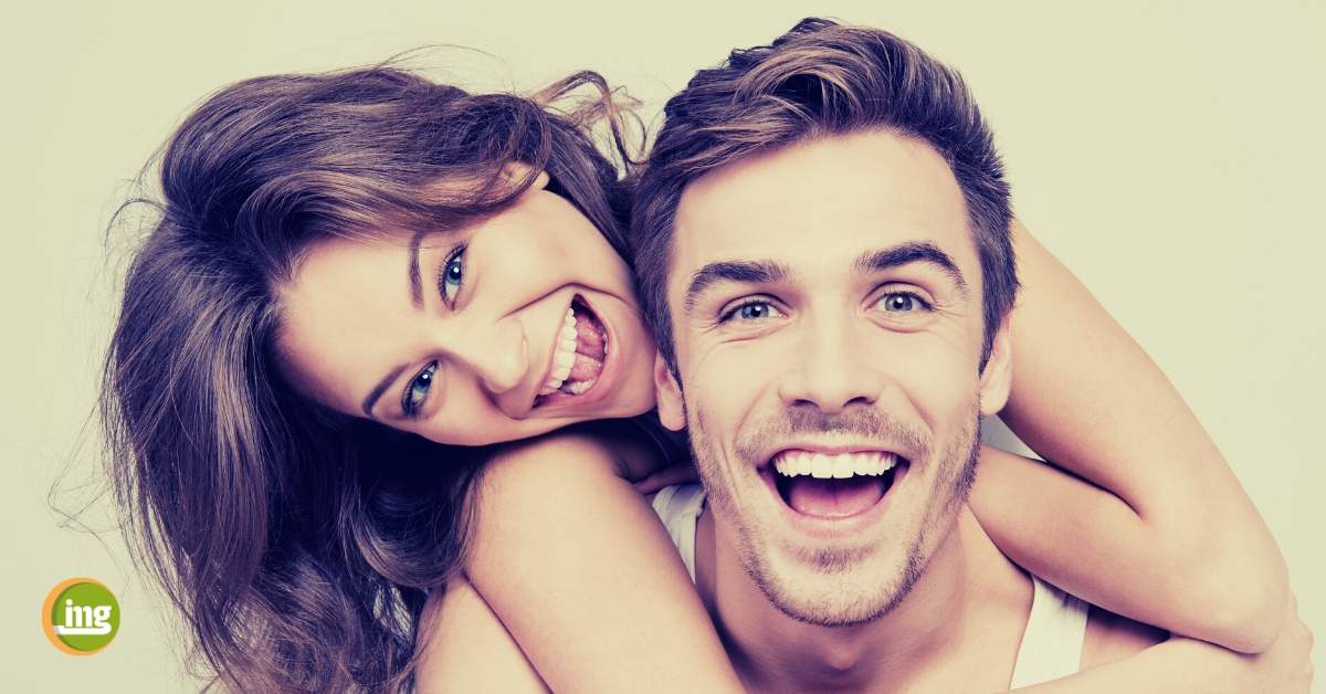 Junges Paar lacht mit schönen Zähnen. Gute Vorsätze für die Mundgesundheit in 2020.