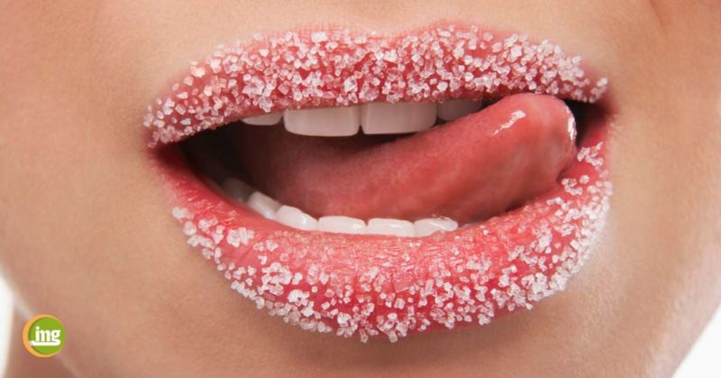 Frau leckt sich die zuckerbestreuten Lippen